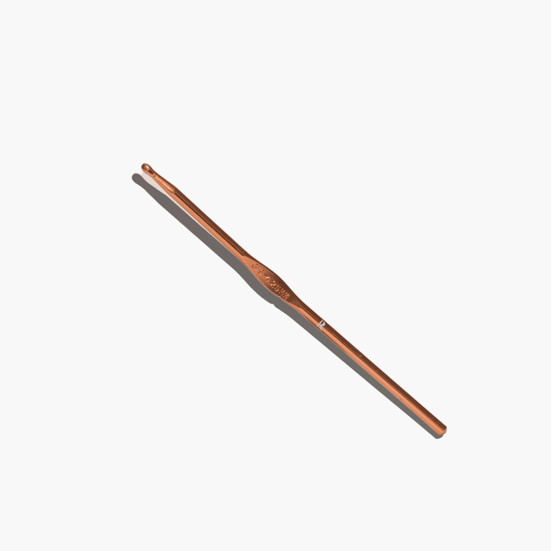 A gold-colored metal hook designed for securing buttons and bustles on a wedding dress, displayed against a white background.