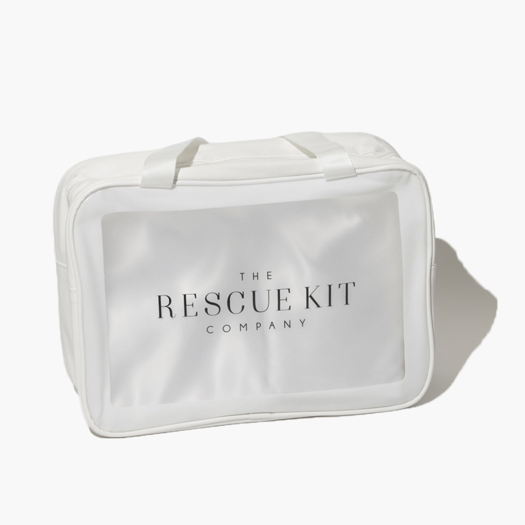 The Bride Kit by The Rescue Kit Company, shown in a white carry bag with top handles and a clear front panel featuring the brand logo—designed to hold bridal emergency essentials.