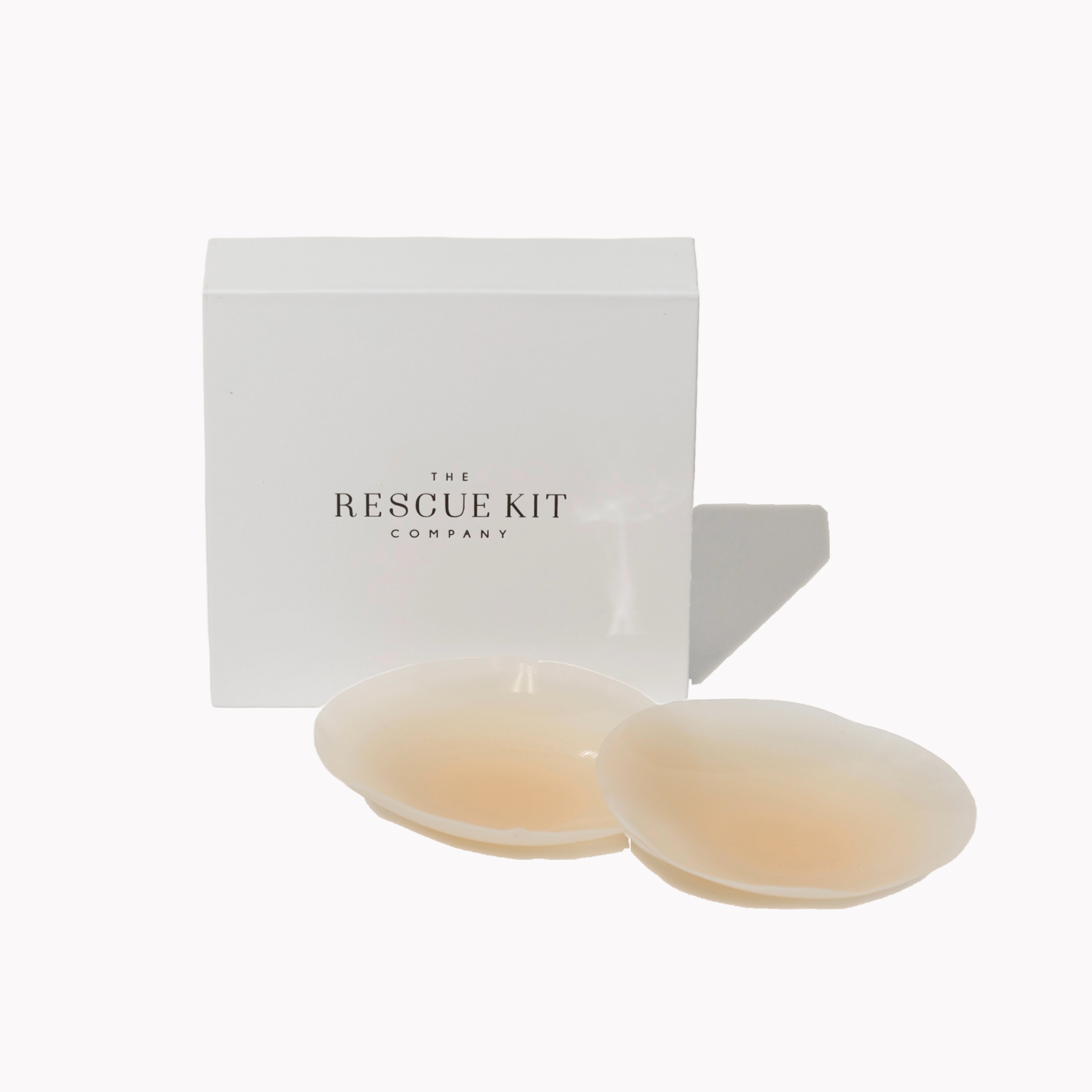 Silicone pasties by The Rescue Kit Company. Two pasties, light skin tone color, outside their white custom packaging box.