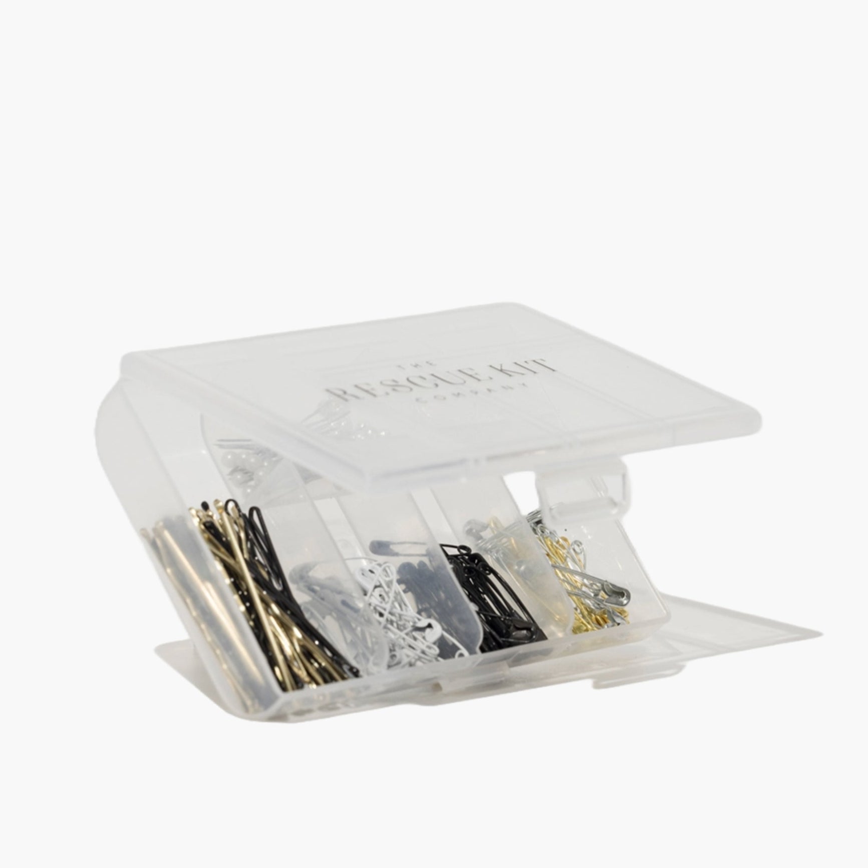 The Rescue Kit Company hair and pin kit, neatly organized in a clear case with assorted bobby pins, safety pins, pearl pins, and elastics in various colors. Shown with top open.