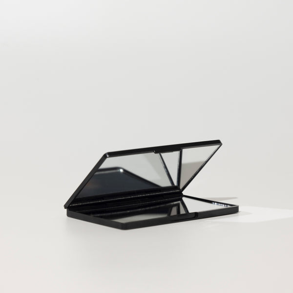 Open black foldable compact mirror from The Rescue Kit Company, shown with multiple reflective panels for versatile use and touch-ups on the go.