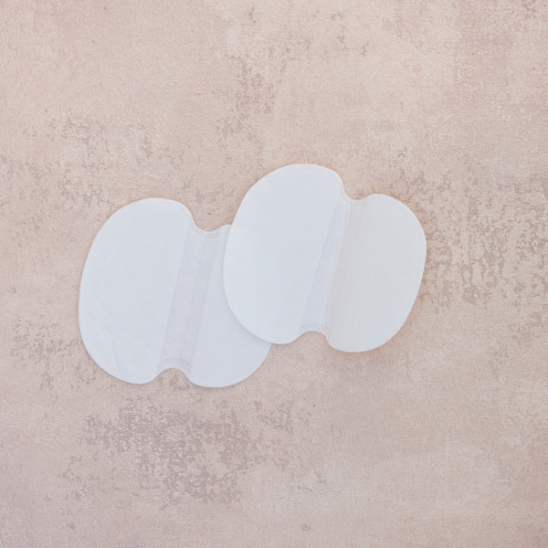 Set of two (four pads total) of white, adhesive, single use sweat pads to protect clothing from stains and wetness from underarms and deodorant.