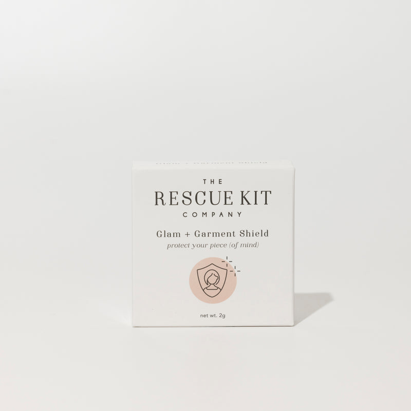 Exterior box of the Glam + Garment Shield by The Rescue Kit Company. White box, pink icon.
