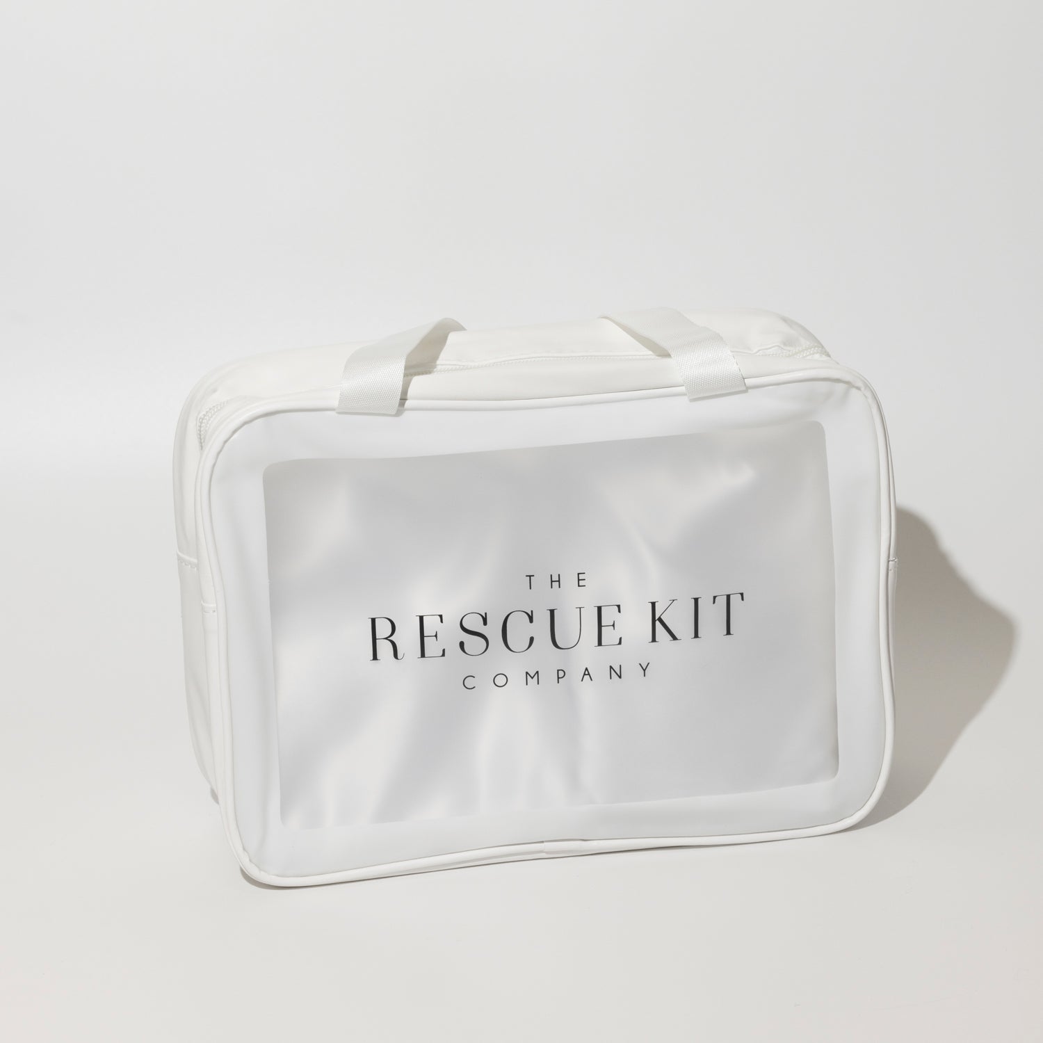 The Bride Kit by The Rescue Kit Company, shown in a white carry bag with top handles and a clear front panel featuring the brand logo—designed to hold bridal emergency essentials.








