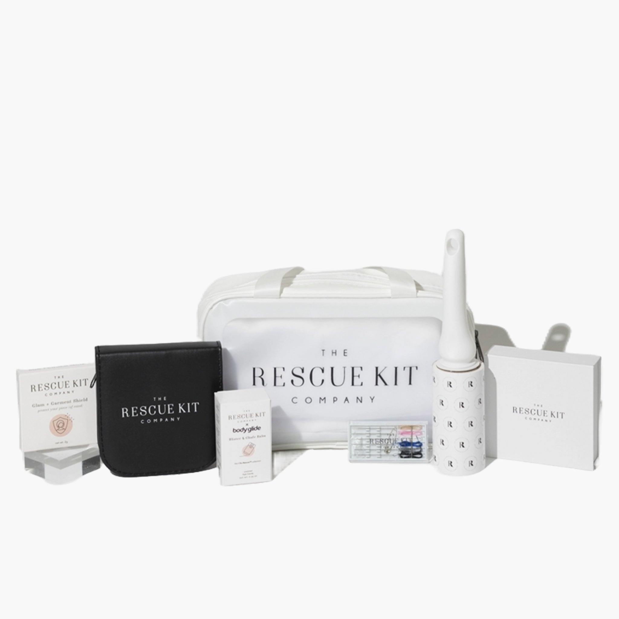 The Bridesmaid Kit by The Rescue Kit Company, featuring a white cosmetic bag, glam + garment shield, body glide, lint roller, mini hair + pin kit, and an open sewing kit with multicolored threads and styling tools.