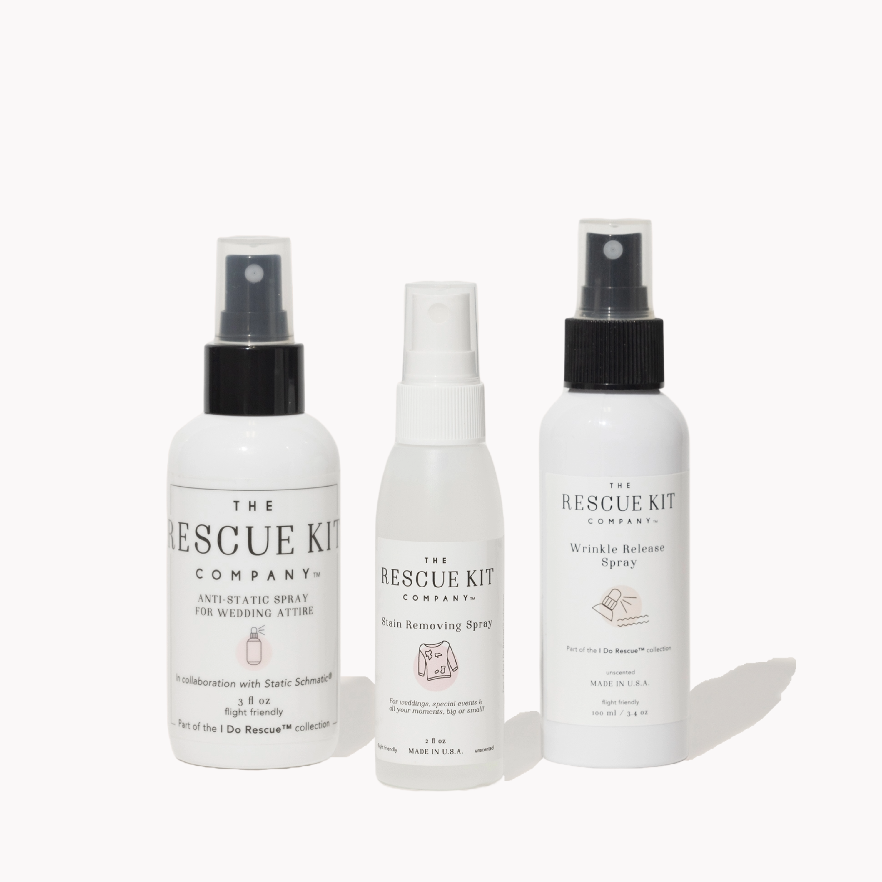 The Spray Trio by The Rescue Kit Company, white bottles, black tops. From left to right: Anti-Static Spray, Stain Removing Spray, and Wrinkle Release Spray.